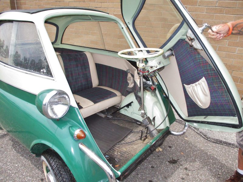 Man from Maltz Auctions holding open a door to vehicle up for auto auction